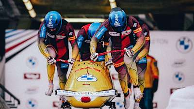 Ein Bobteam beim Start im Viererbob.