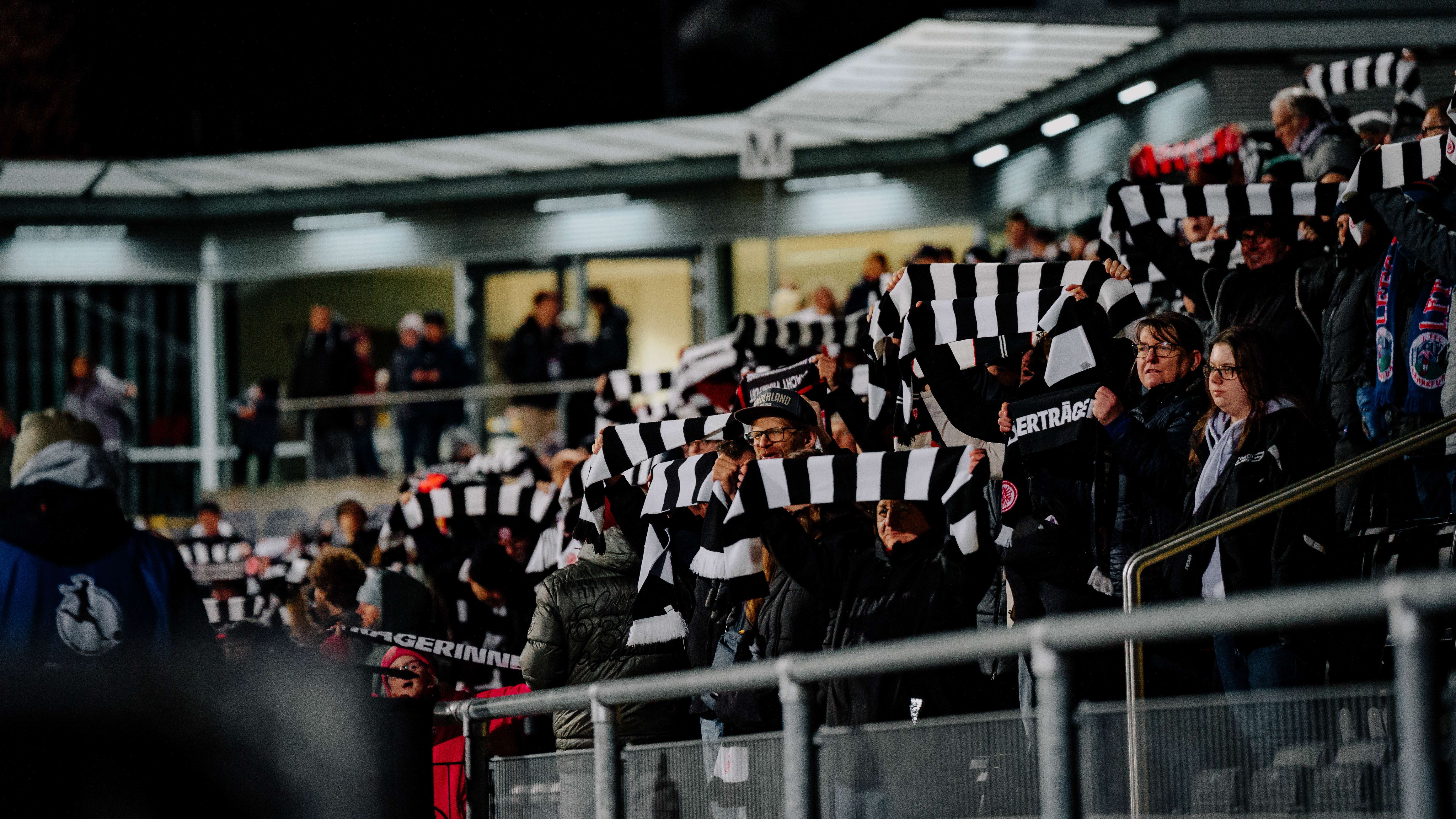 Eintracht-Fans halten im Stadion am Brentanobad ihre Schals in die Luft Eintracht-Fans halten im Stadion am Brentanobad ihre Schals in die Luft
