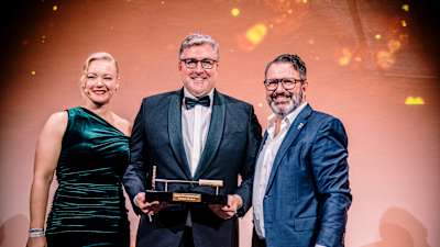 Eintracht-Vorstandssprecher Axel Hellmann nimmt das Goldene Brandeisen entgegen. Alicja Feltens, Chefin des Marketingclubs, und Vorjahressieger Ulrich Klenke, Chief Brand Officer der Telekom, gratulieren.