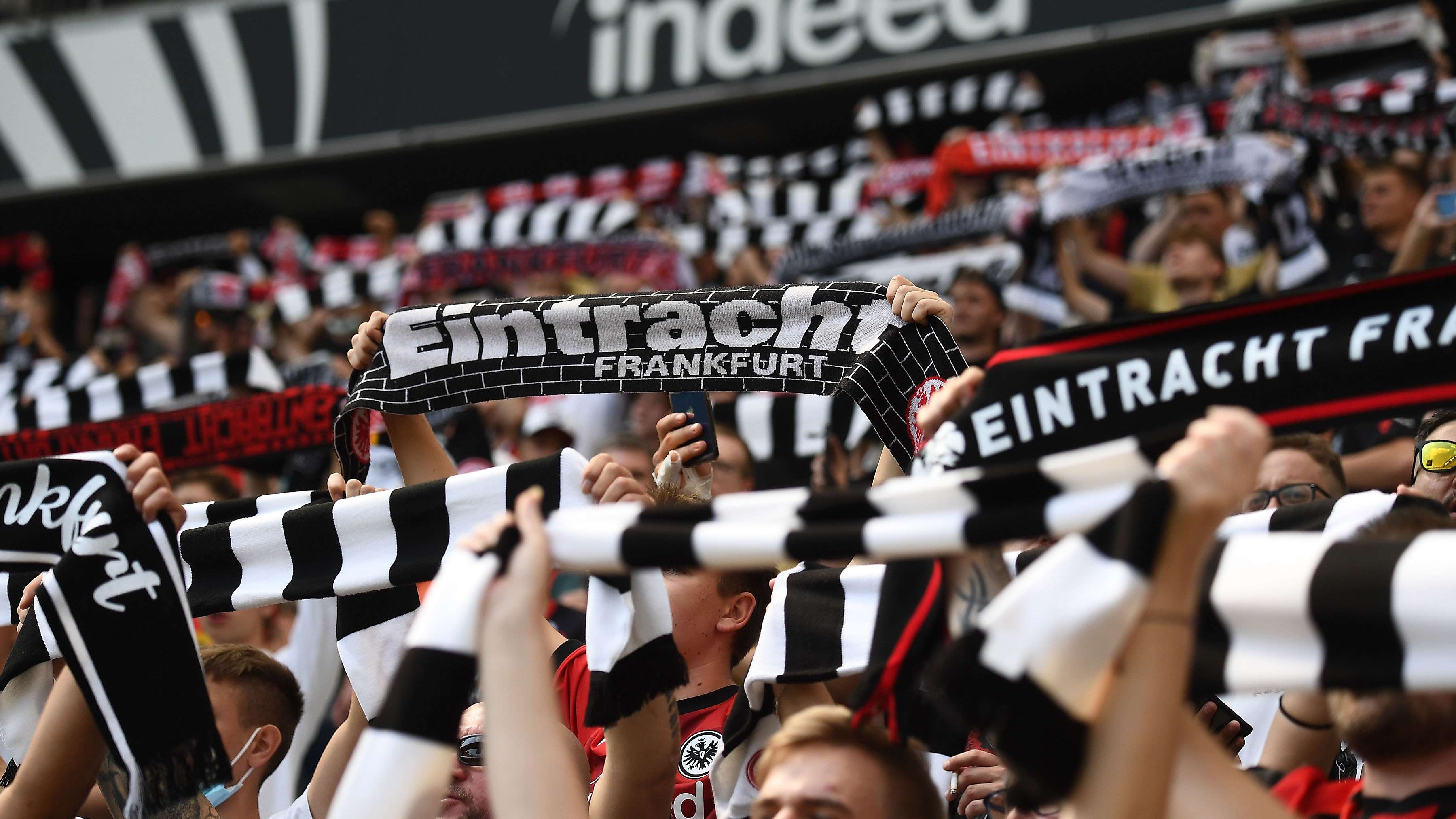 Eintracht-Fans die ihren Schal hochhalten Eintracht-Fans die ihren Schal hochhalten