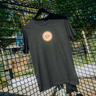 Schwarzes Eintracht Frankfurt T-Shirt mit Vereinslogo auf der Brust, vor Tornetz-Hintergrund. Nike T-Shirt Logo Schwarz
