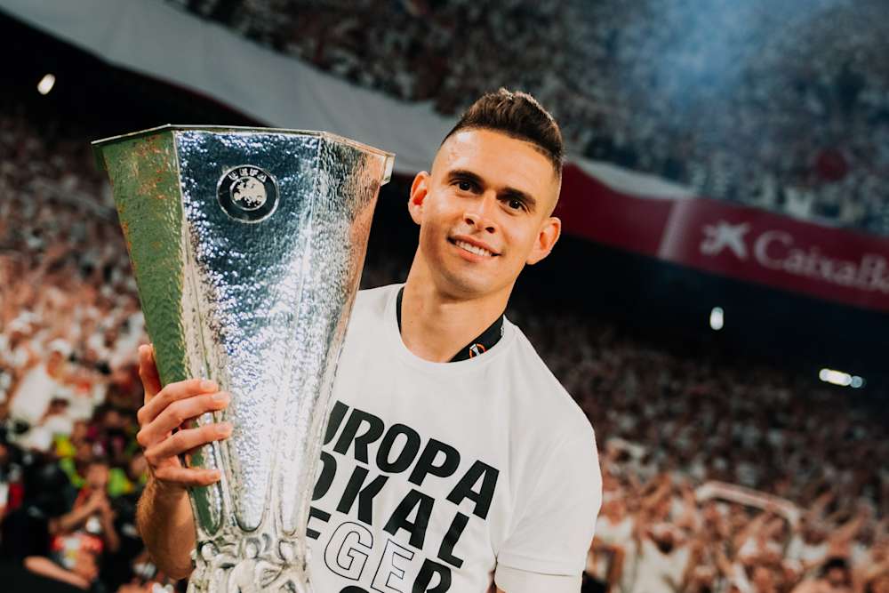 Stürmer Rafael Borre hält die Trophäe der Europa League.
