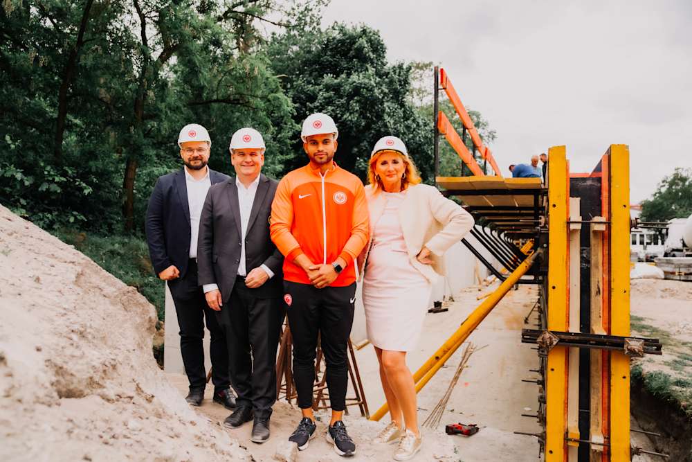 Niclas Rommel, Eintracht-Präsident Mathias Beck, Bobsportler Joshua Tasche und Erica Fischbach stehen auf der Baustelle.