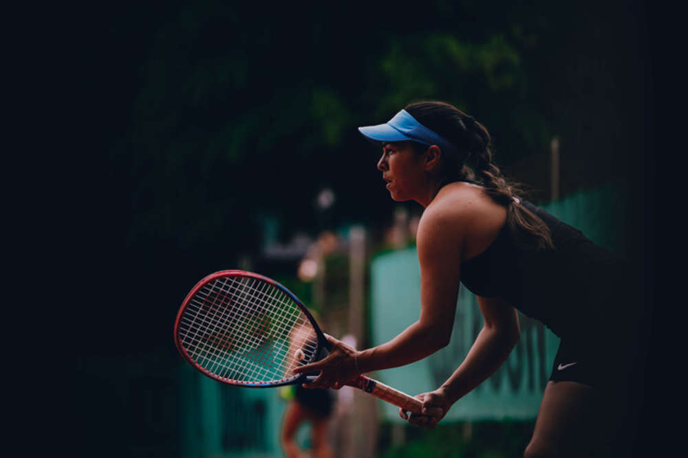 Eileen Aranas-Roth von der Seite beim Tennisspielen, sie wartet konzentriert auf den Ball.