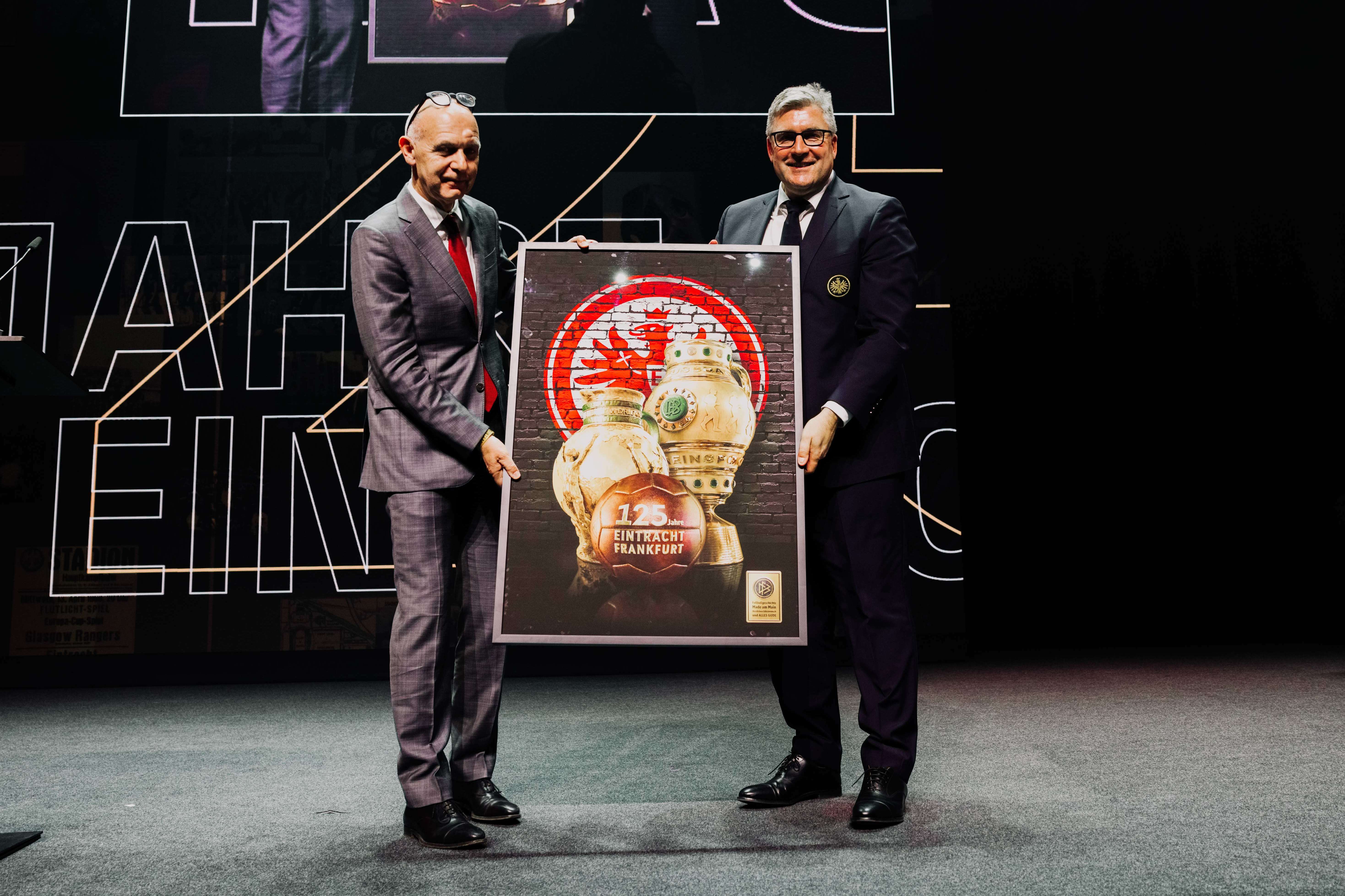 DFB-Präsident Bernd Neuendorf überreicht Eintracht-Vorstandssprecher Axel Hellmann ein aussagekräftiges Gastgeschenk. DFB-Präsident Bernd Neuendorf überreicht Eintracht-Vorstandssprecher Axel Hellmann ein aussagekräftiges Gastgeschenk.